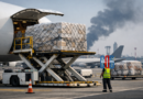 Cargo aircraft being loaded at an international airport amid rising air freight demand due to Middle East conflict disruptions.