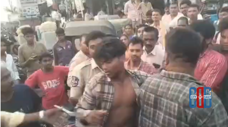 Police detain a suspected thief caught by locals at Maripeda vegetable market